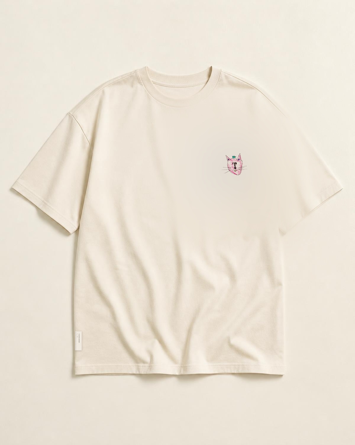 The Founding Tee in ivory organic cotton, with Mila's small original cat on the left chest